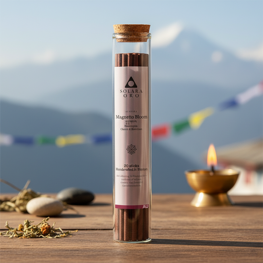 Glass tube with incense sticks labeled 'Solara Org' on a wooden surface with a mountain and flags in the background.