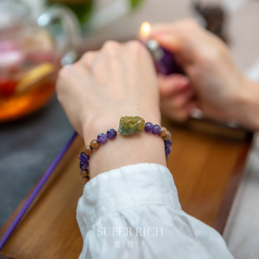 Person wearing a beaded bracelet with a lit lighter in the background