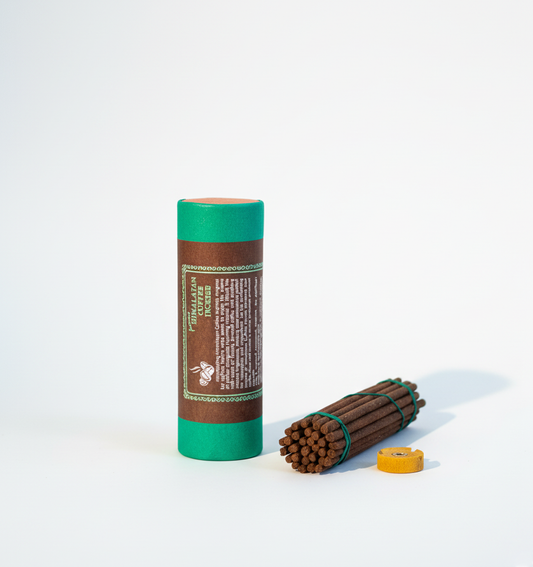 Cylindrical green and brown product with wooden sticks on a white background