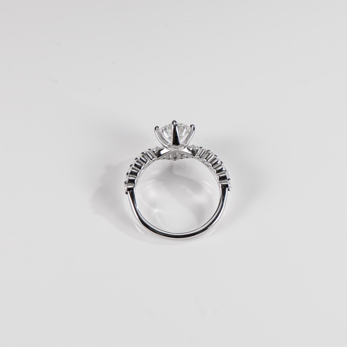 Silver ring with a diamond on a light gray background