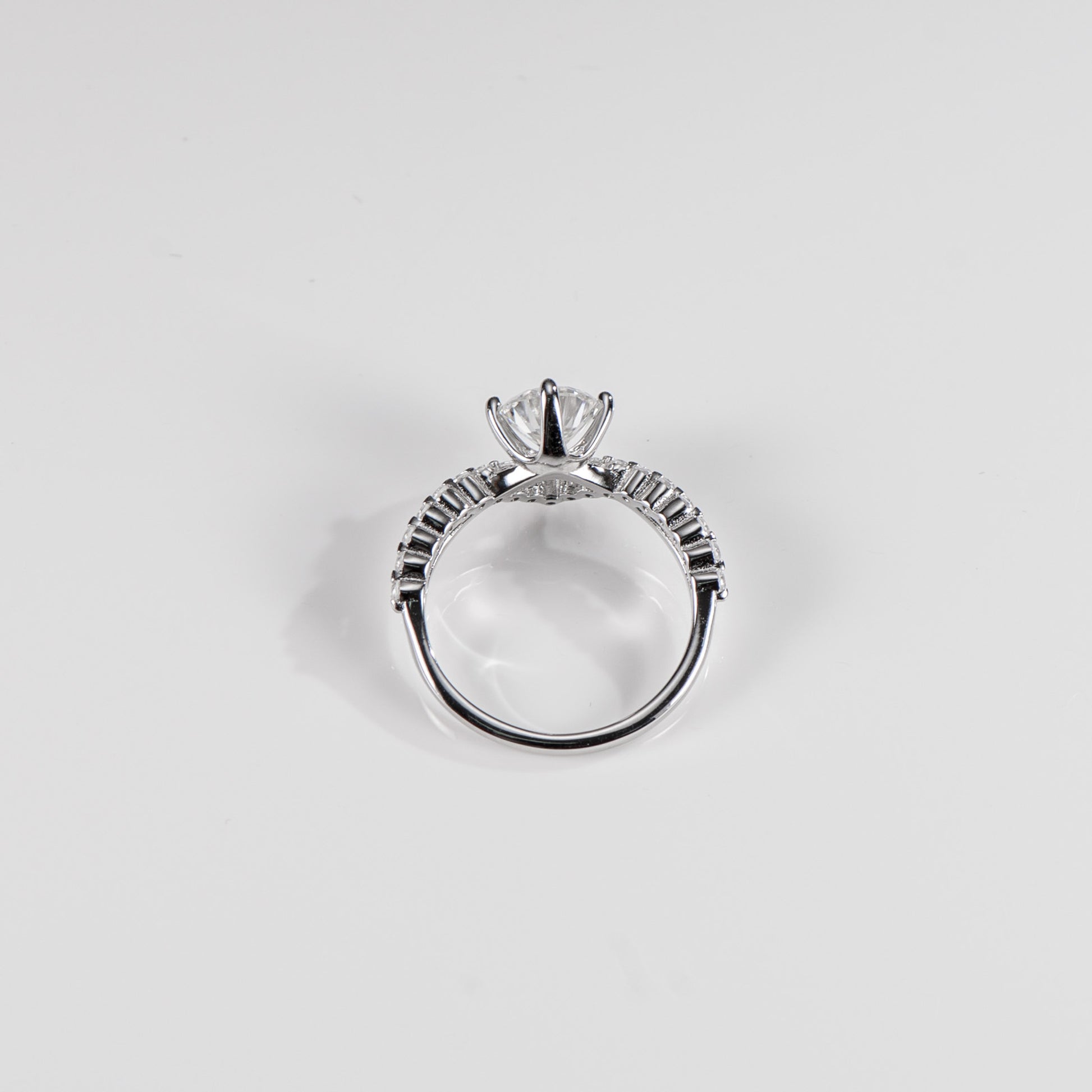 Silver ring with a diamond on a light gray background