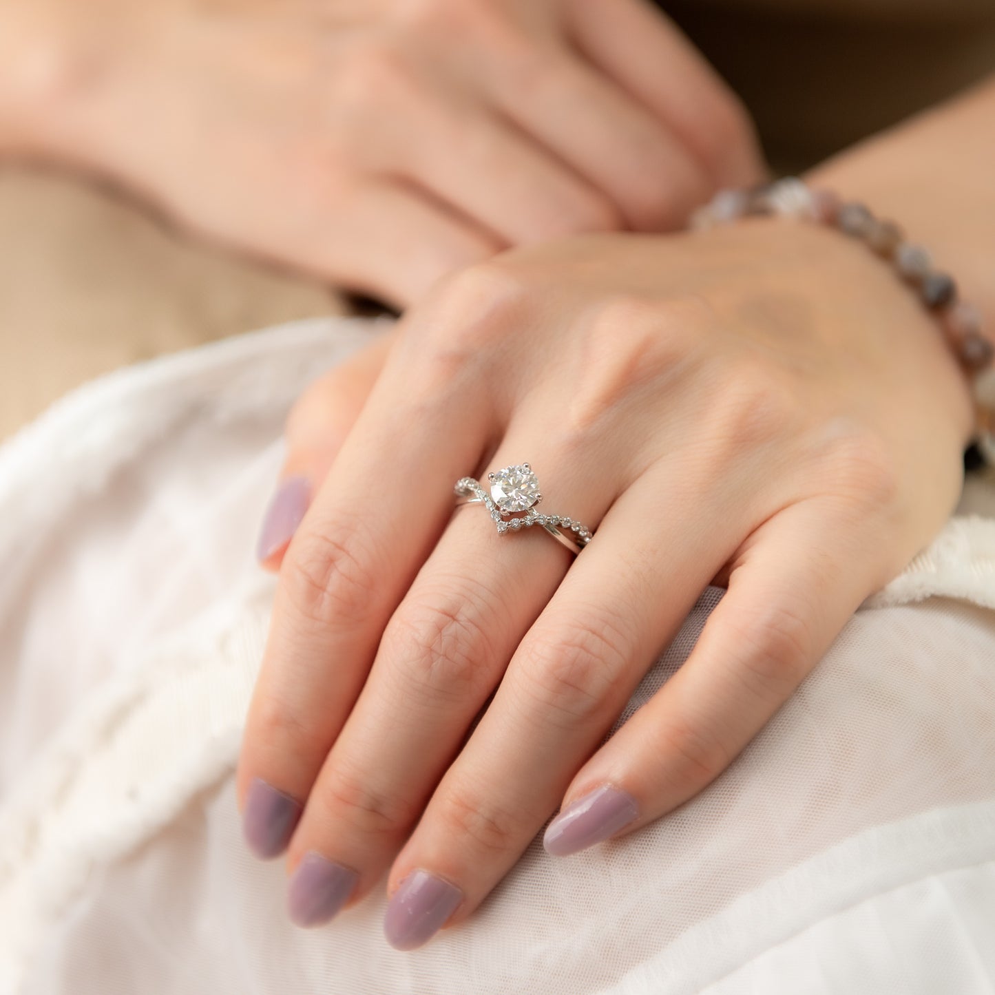 Close-up of a hand wearing an engagement ring with a soft focus background