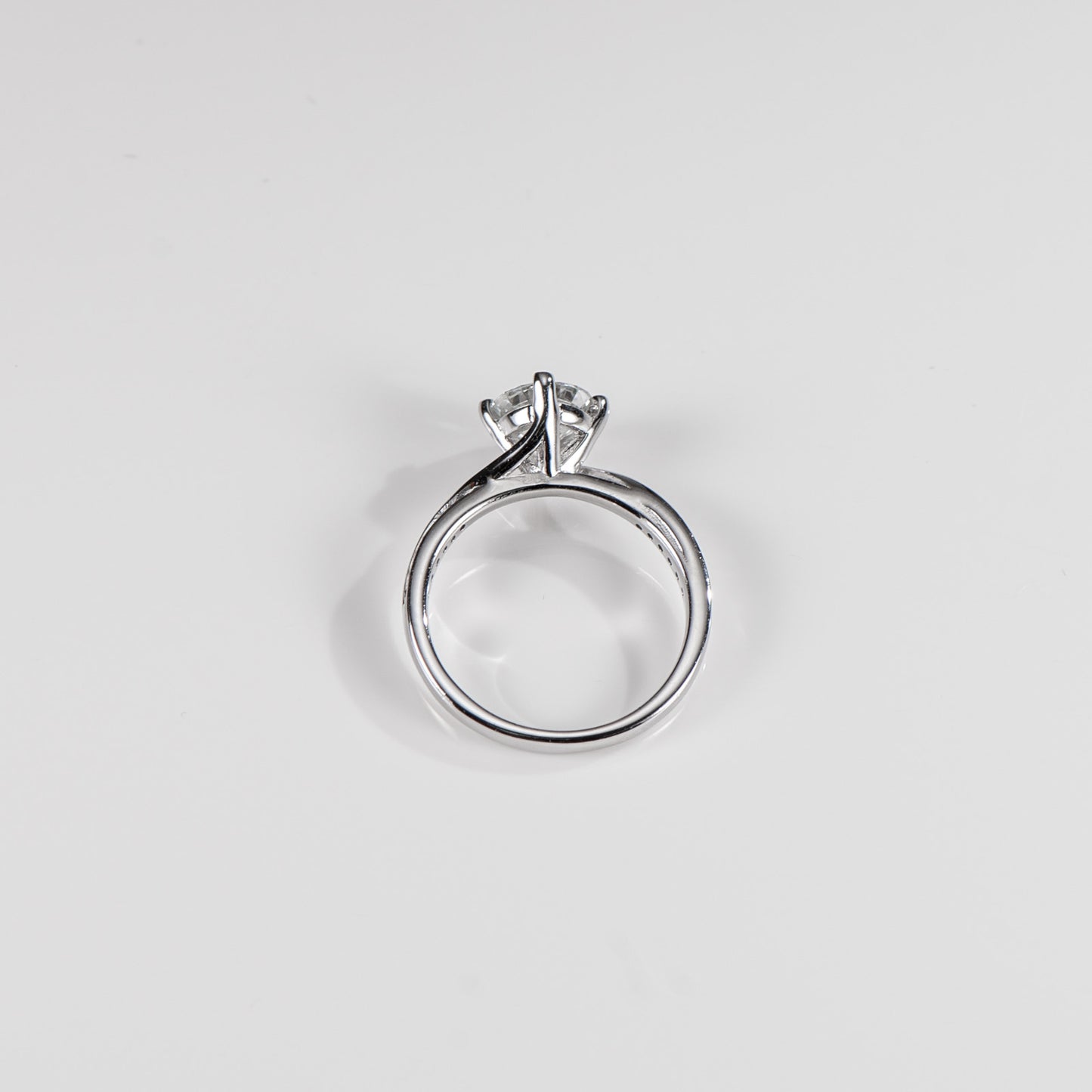 Silver ring with a diamond on a light gray background