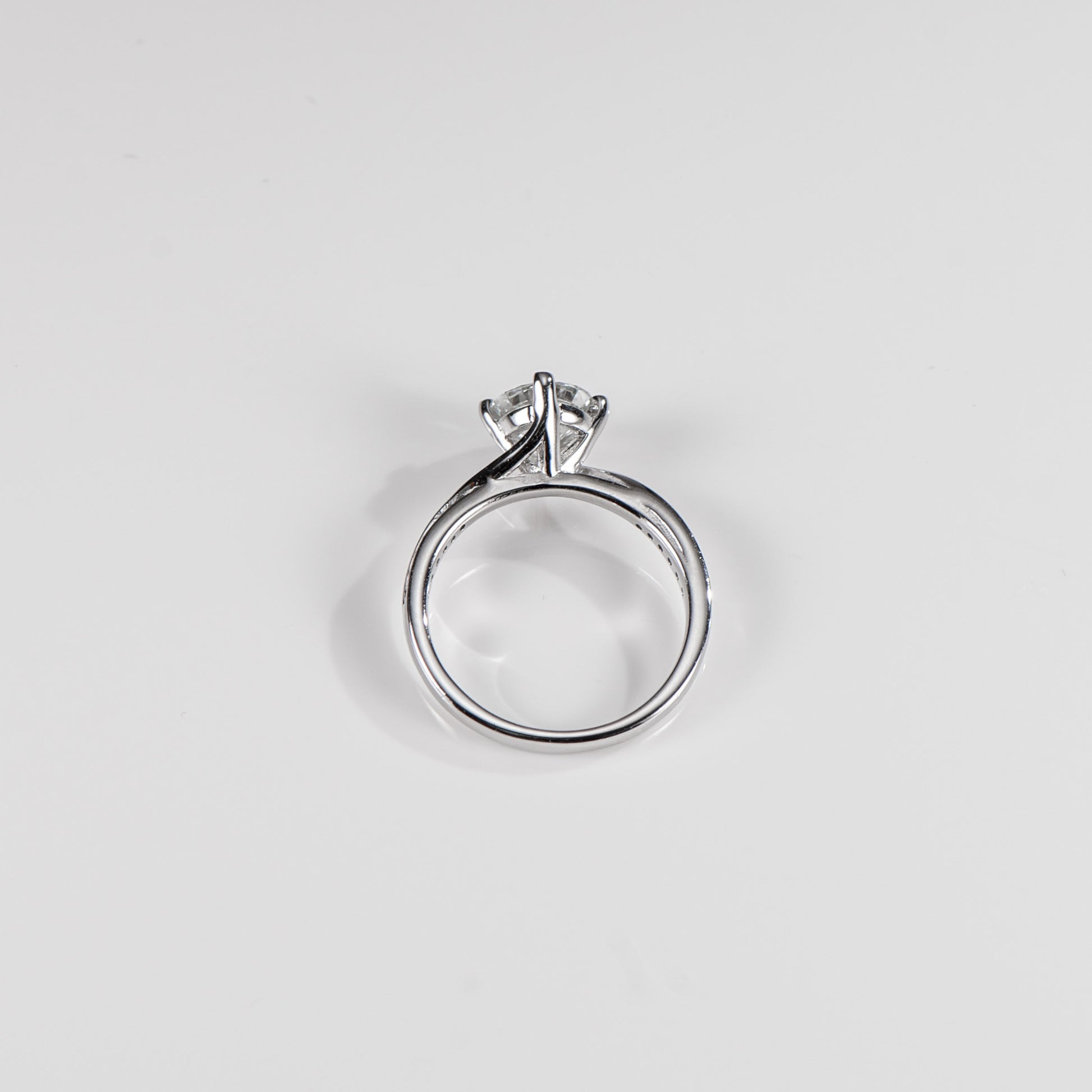 Silver ring with a diamond on a light gray background