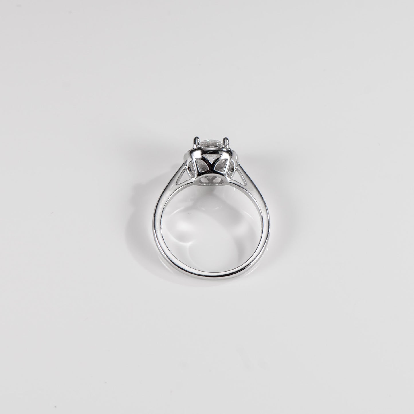 Silver ring with a diamond on a light gray background