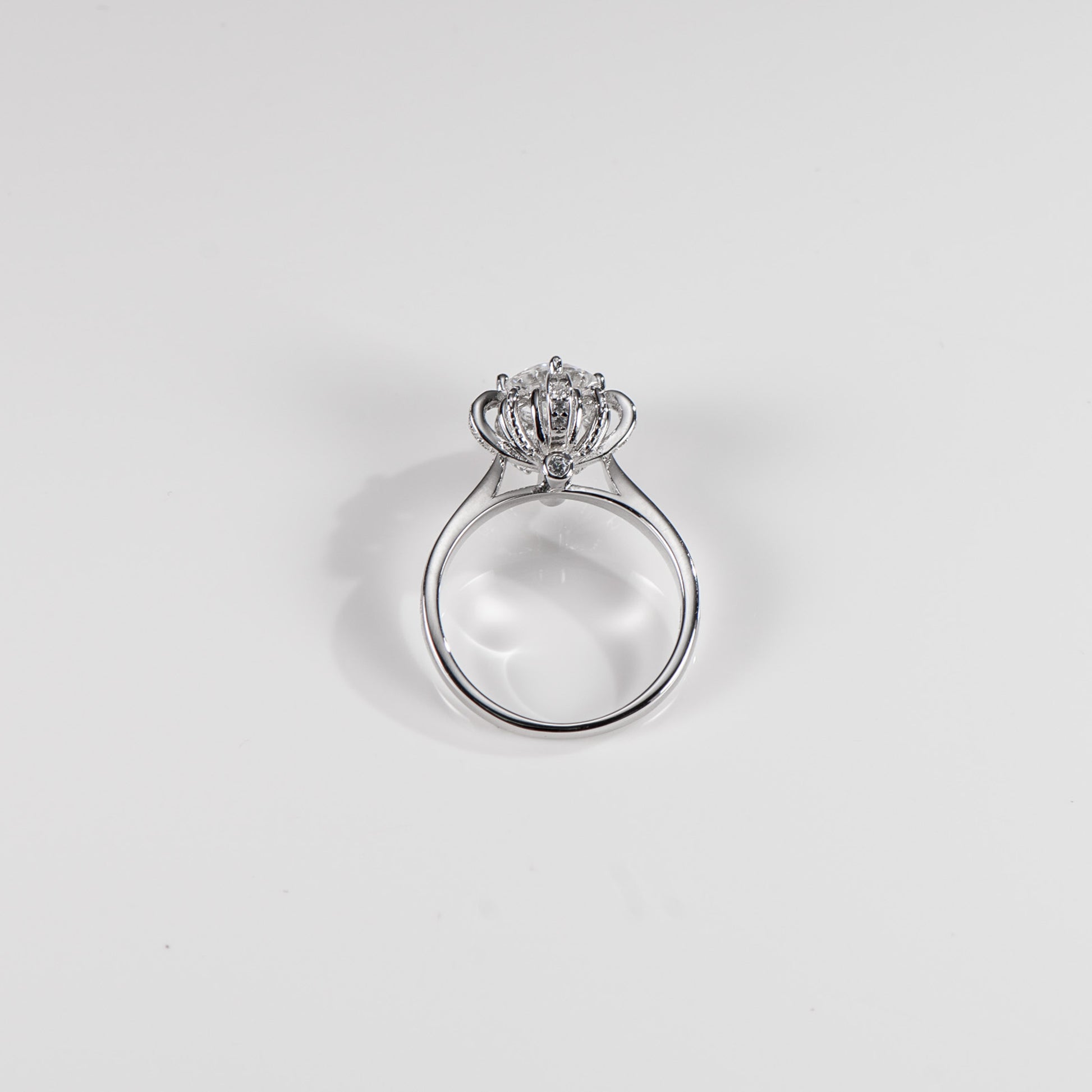Silver ring with a diamond on a light gray background
