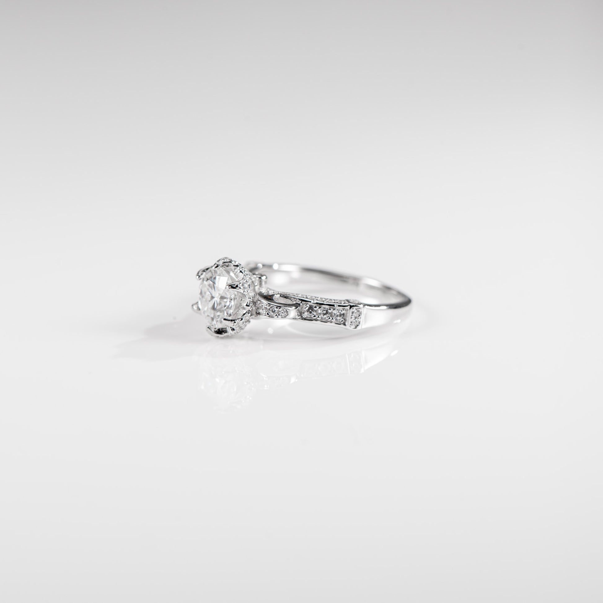 Silver ring with a diamond on a light gray background