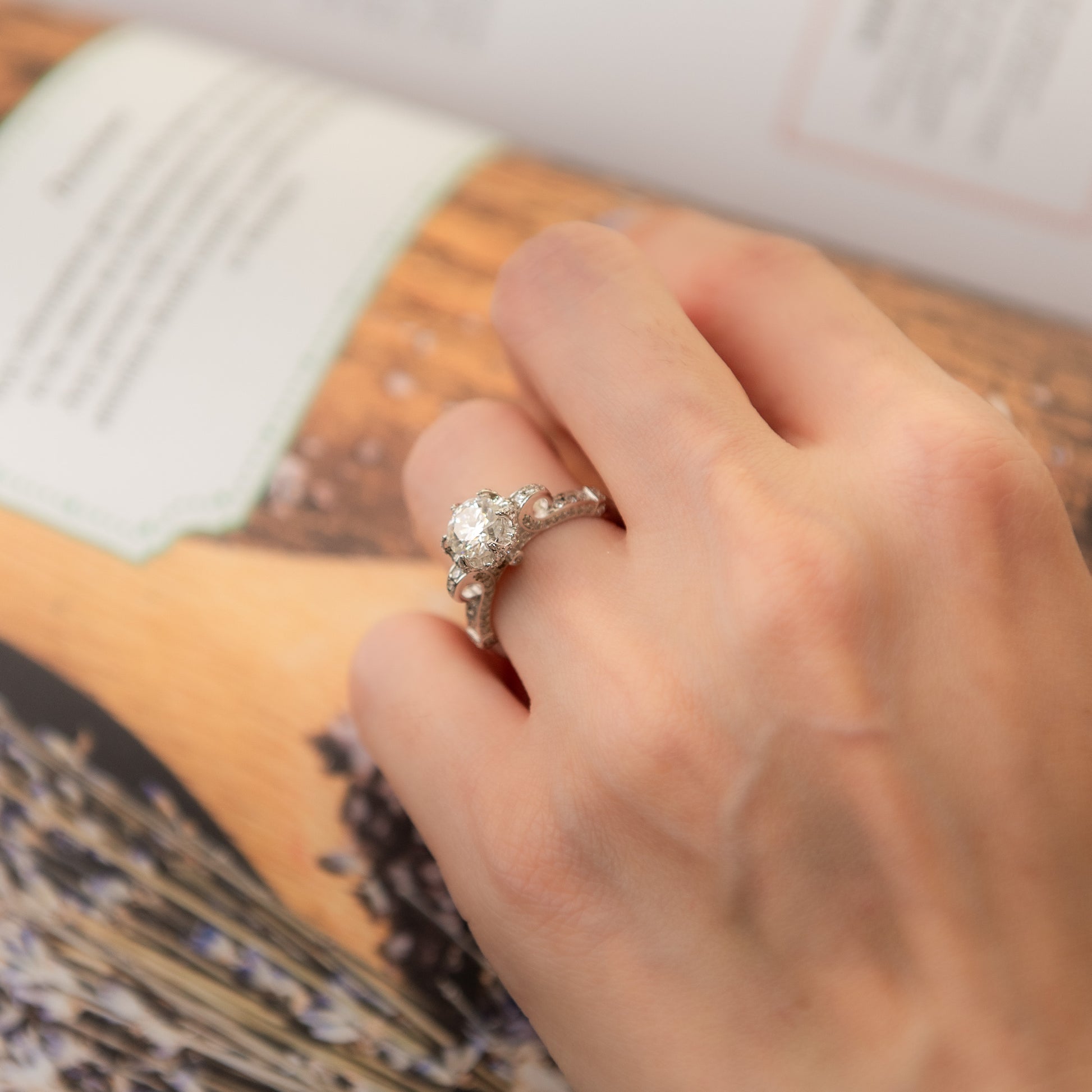 Hand wearing a diamond ring on a patterned surface