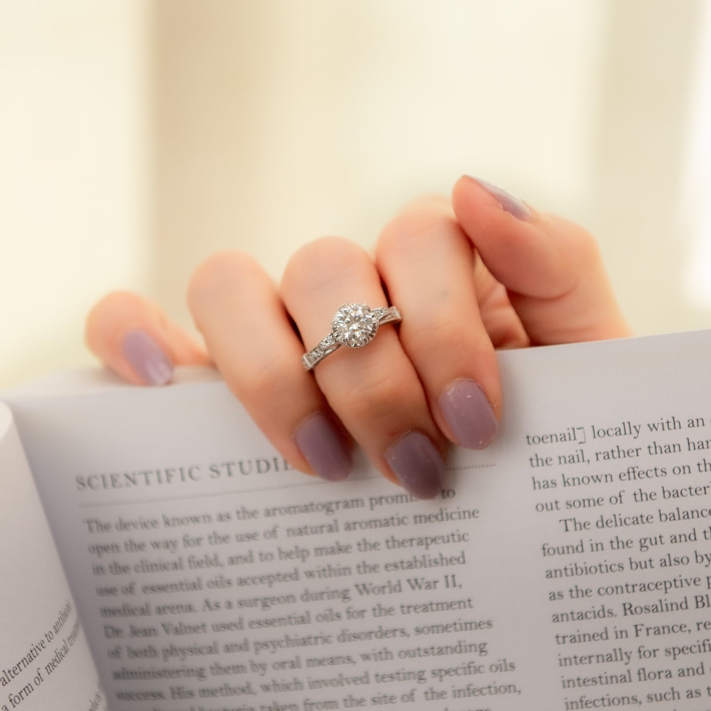 Hand with a diamond ring on an open book