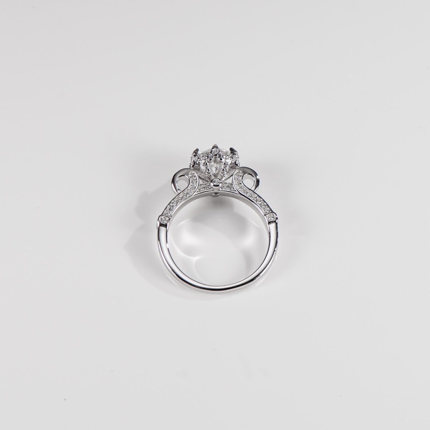 Silver ring with a diamond on a light gray background