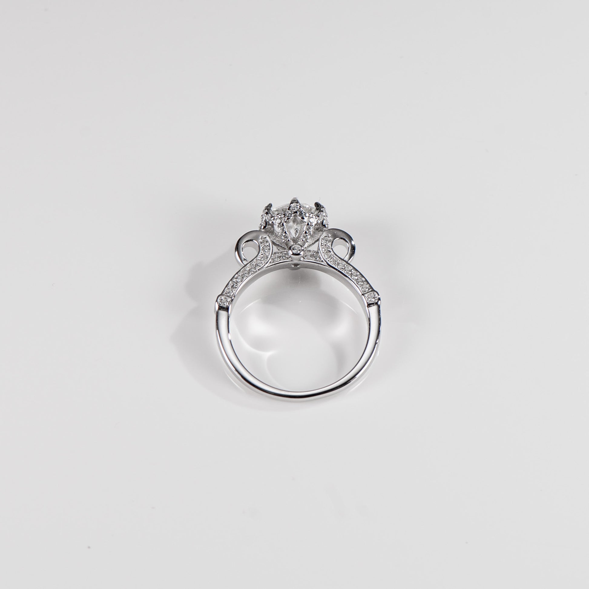 Silver ring with a diamond on a light gray background