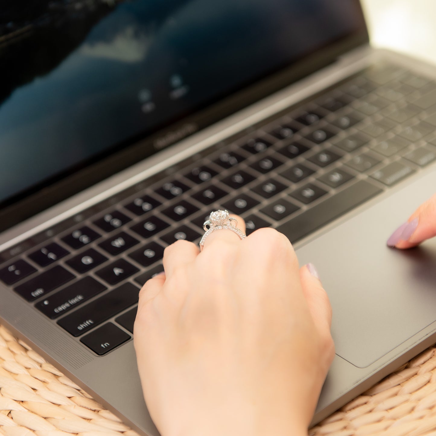 Person using a laptop with a hand on the keyboard