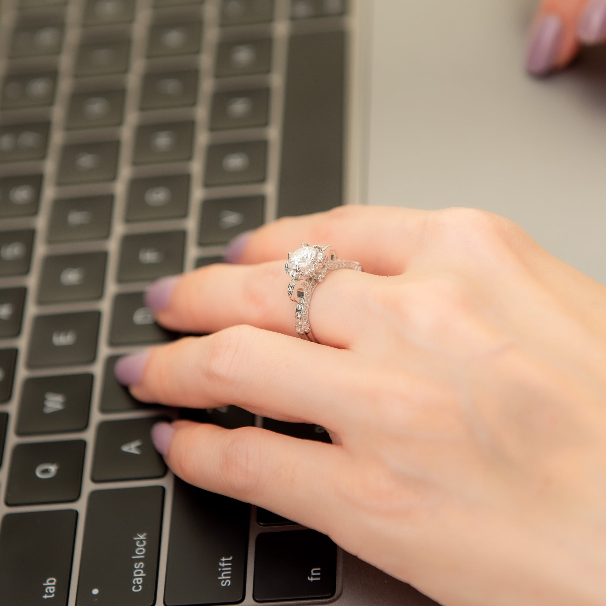 Hand with a ring on a laptop keyboard