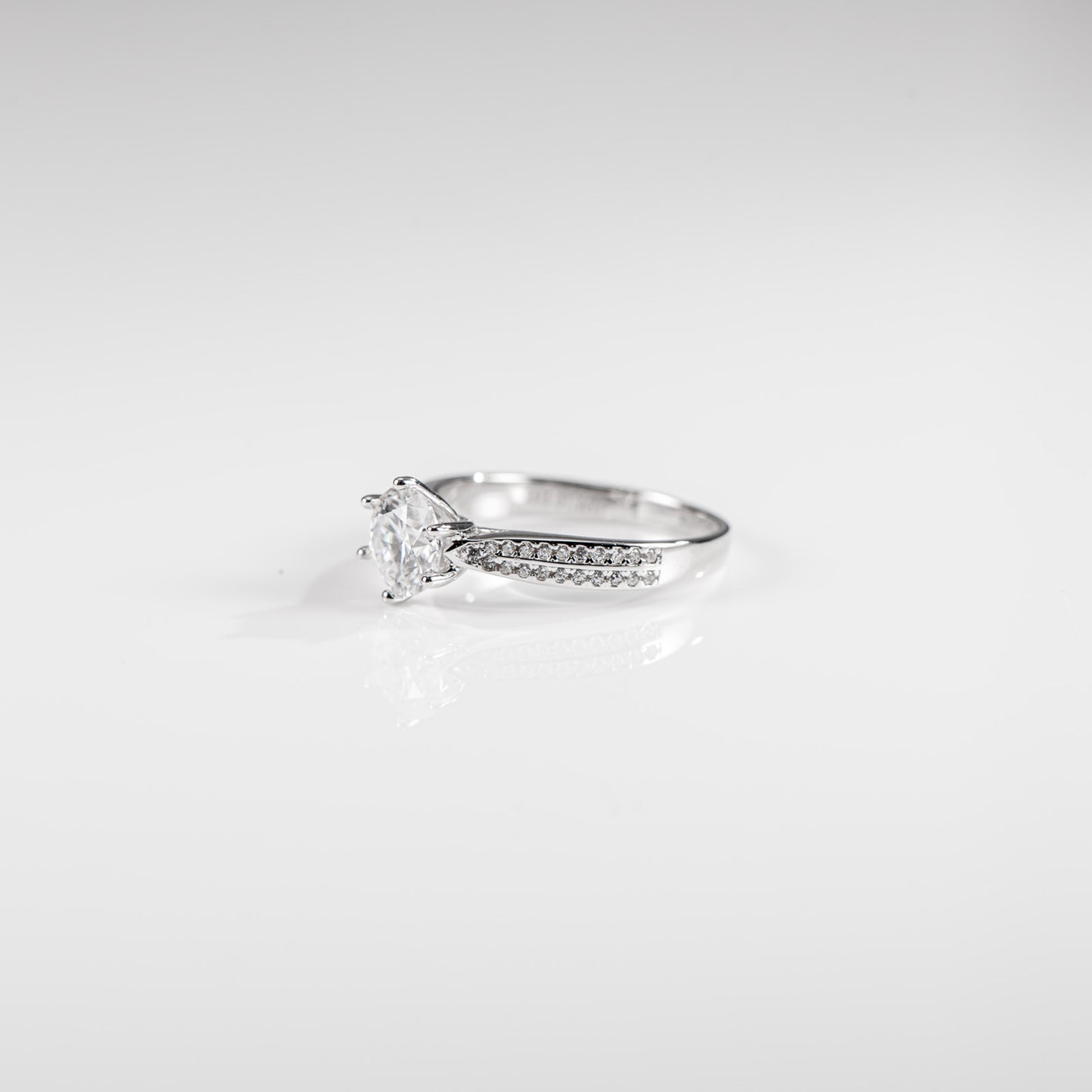 Silver ring with a diamond on a light gray background
