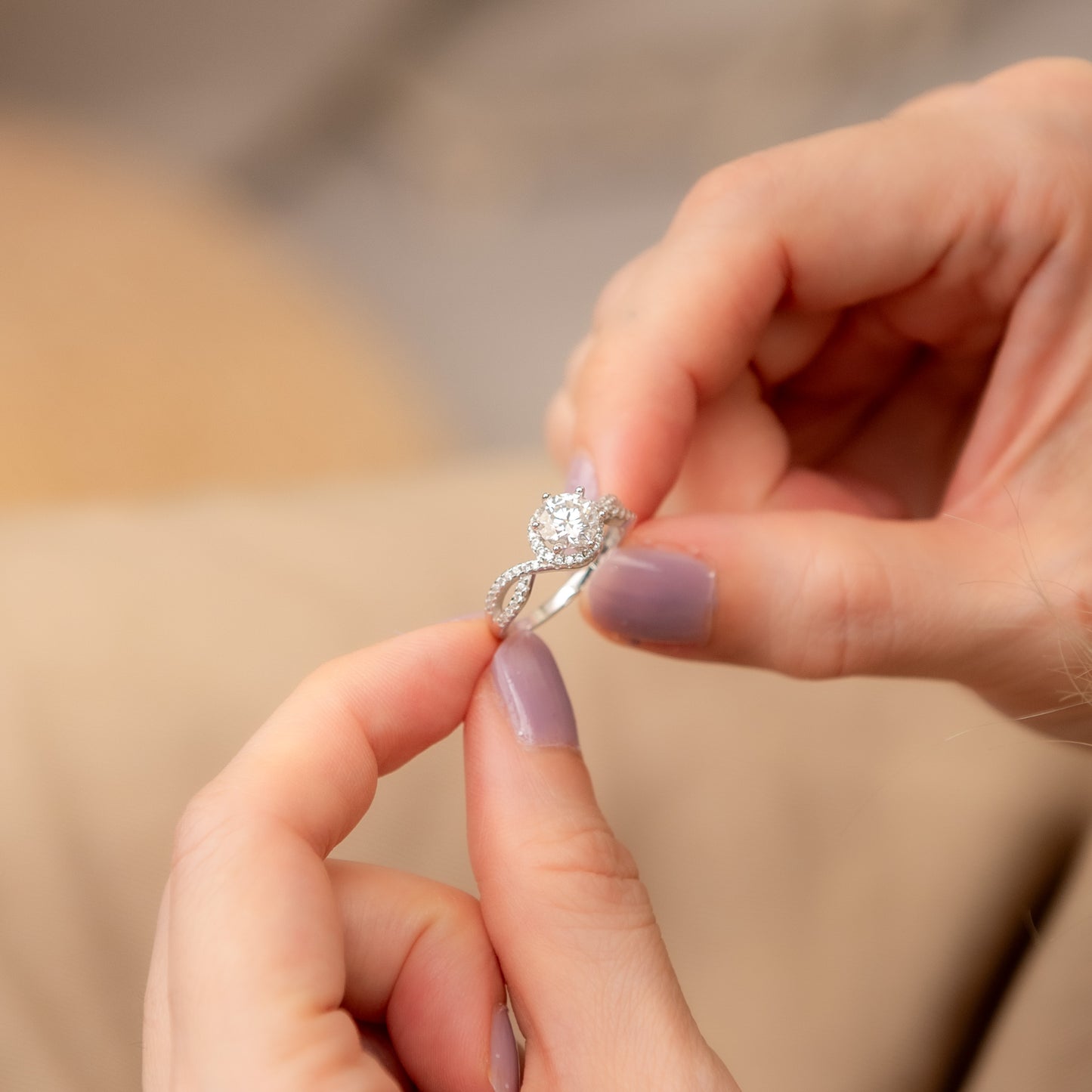 Close-up of hands holding a silver ring with a diamond