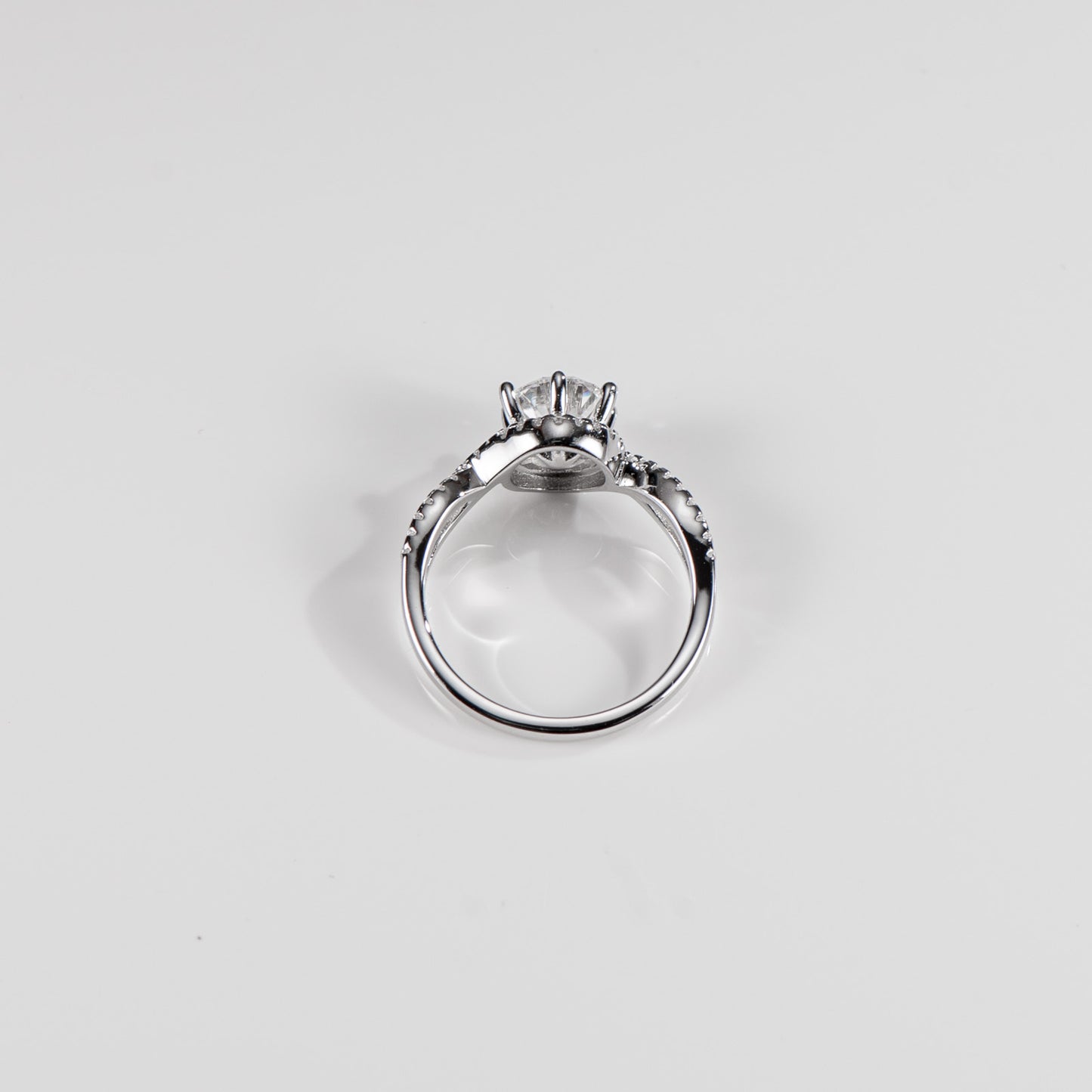 Silver ring with a diamond on a light gray background
