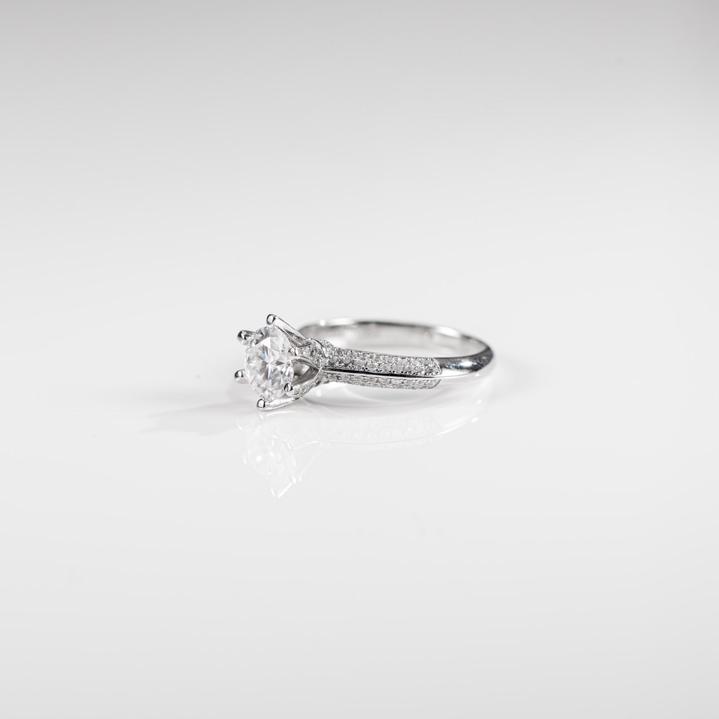 Silver ring with a diamond on a light gray background