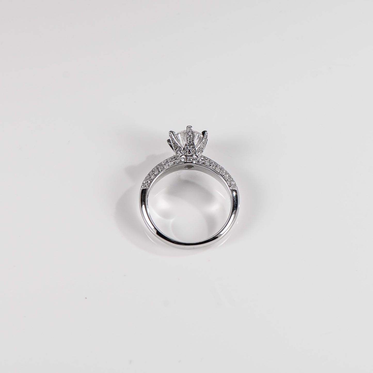 Silver ring with a diamond on a light gray background