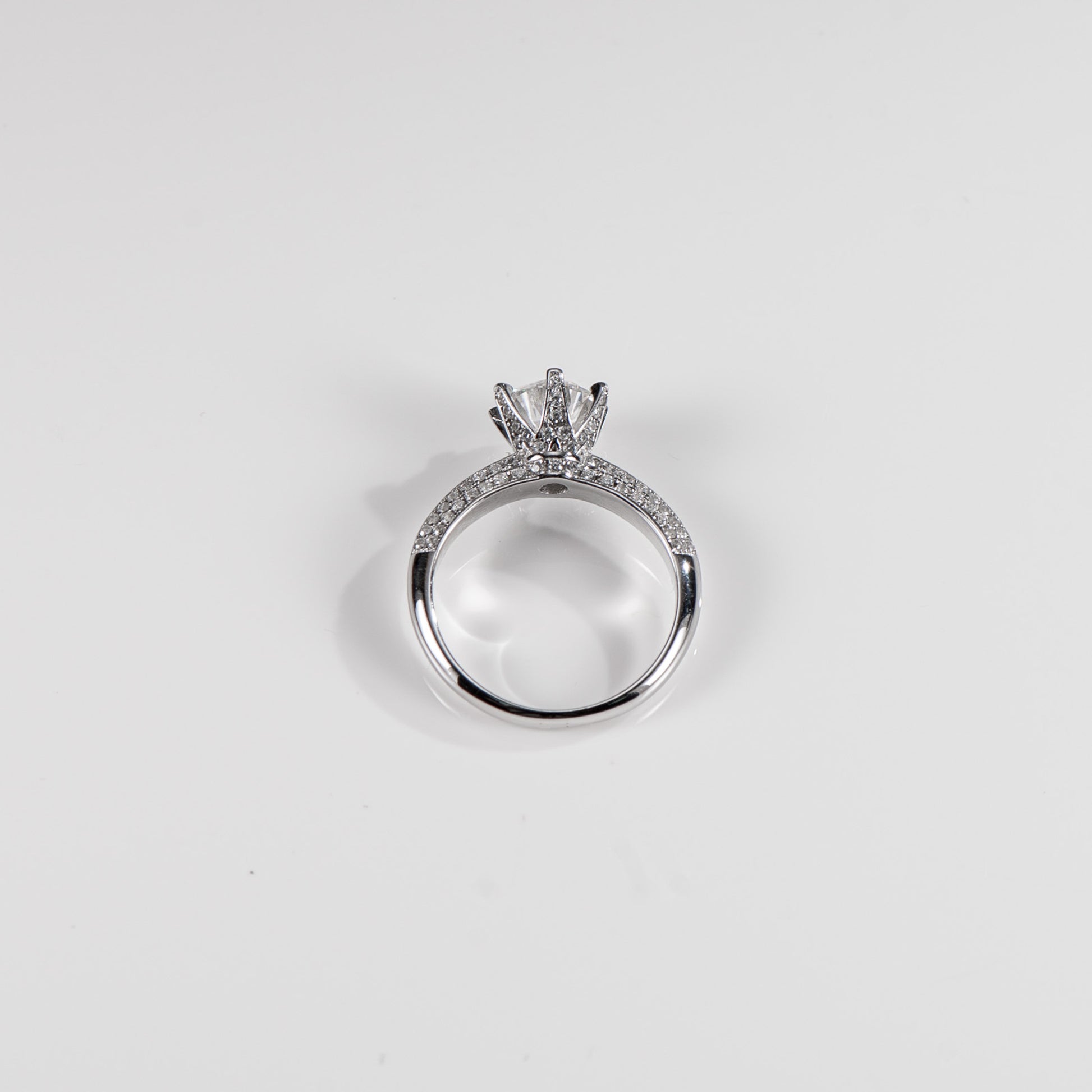 Silver ring with a diamond on a light gray background