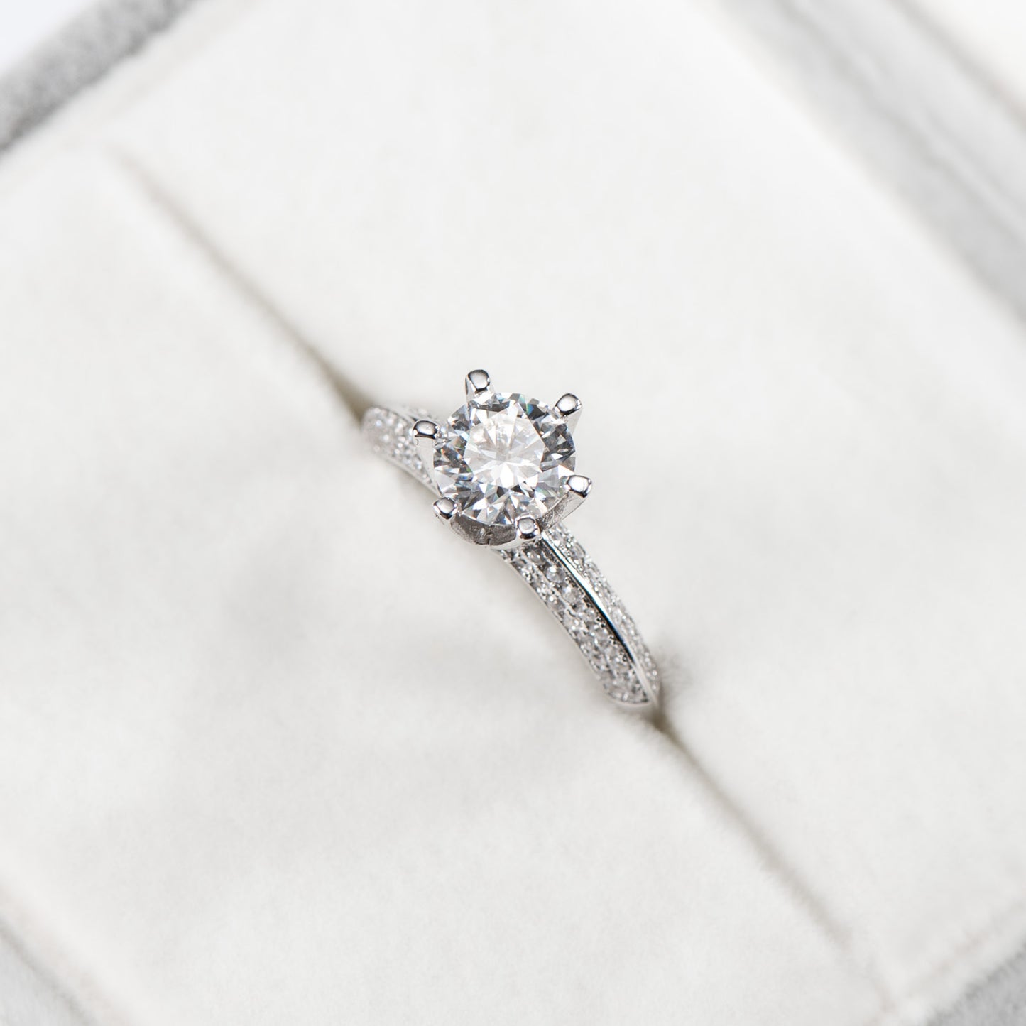 Diamond ring on a white cushioned surface