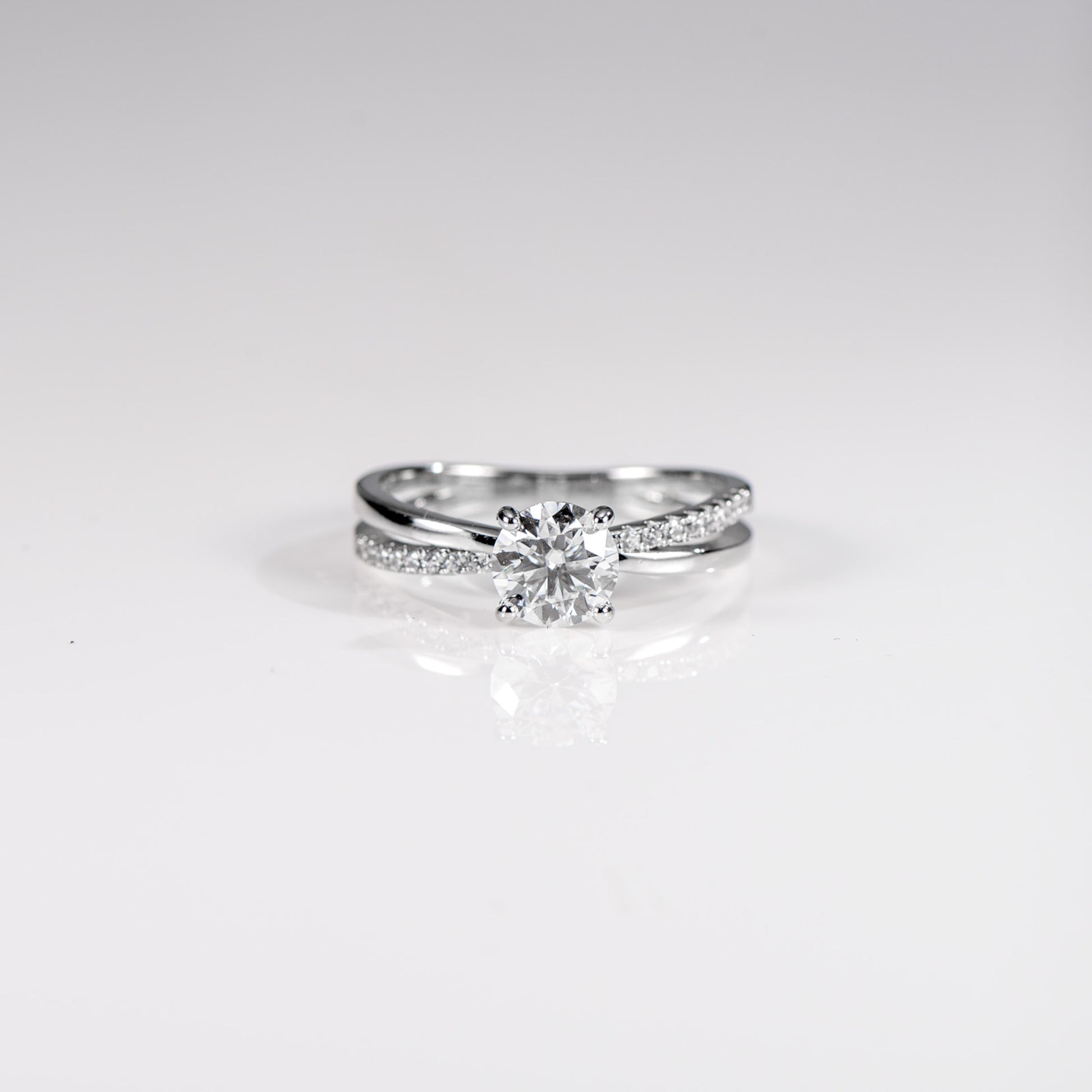 Silver ring with a diamond on a light gray background