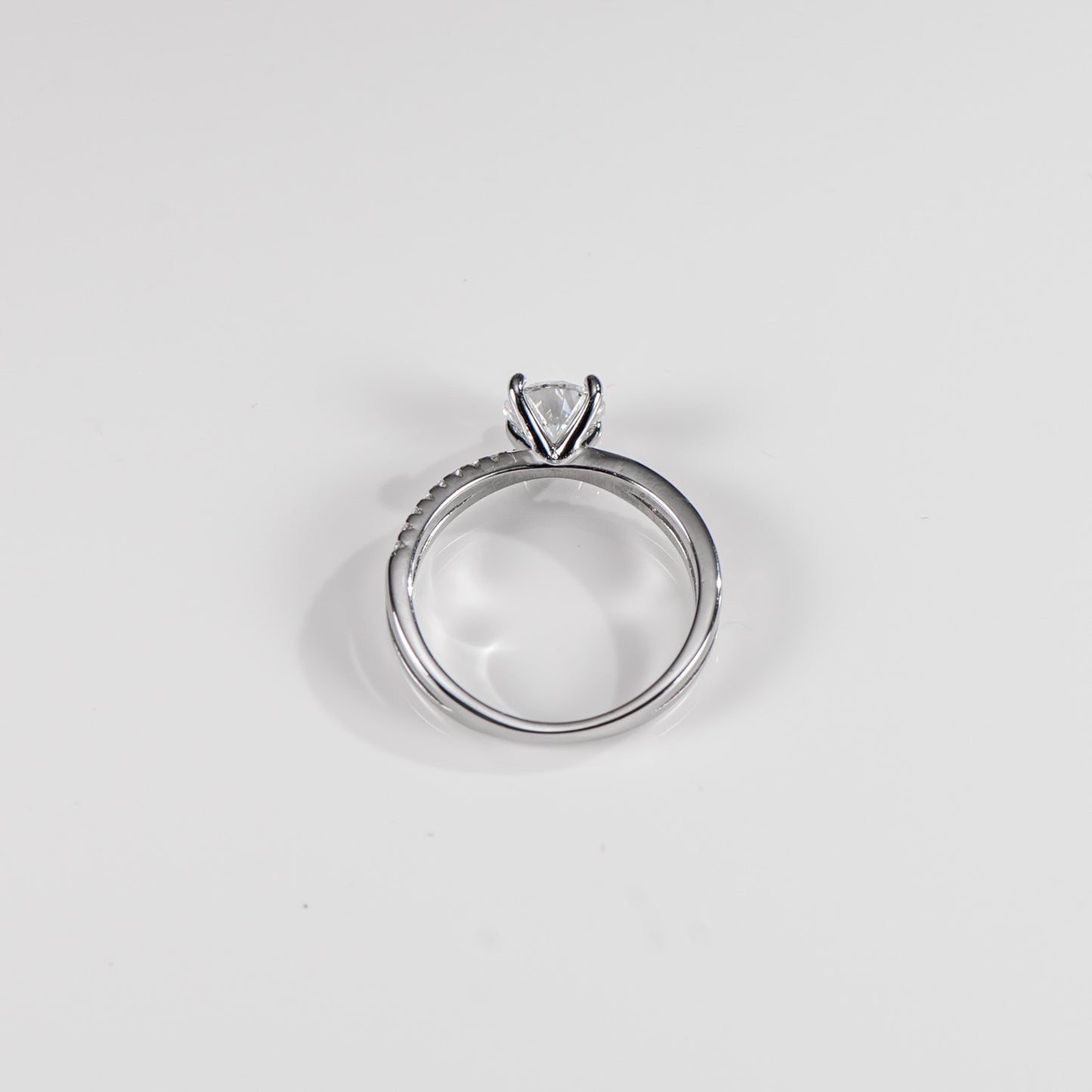 Silver ring with a clear gemstone on a light gray background