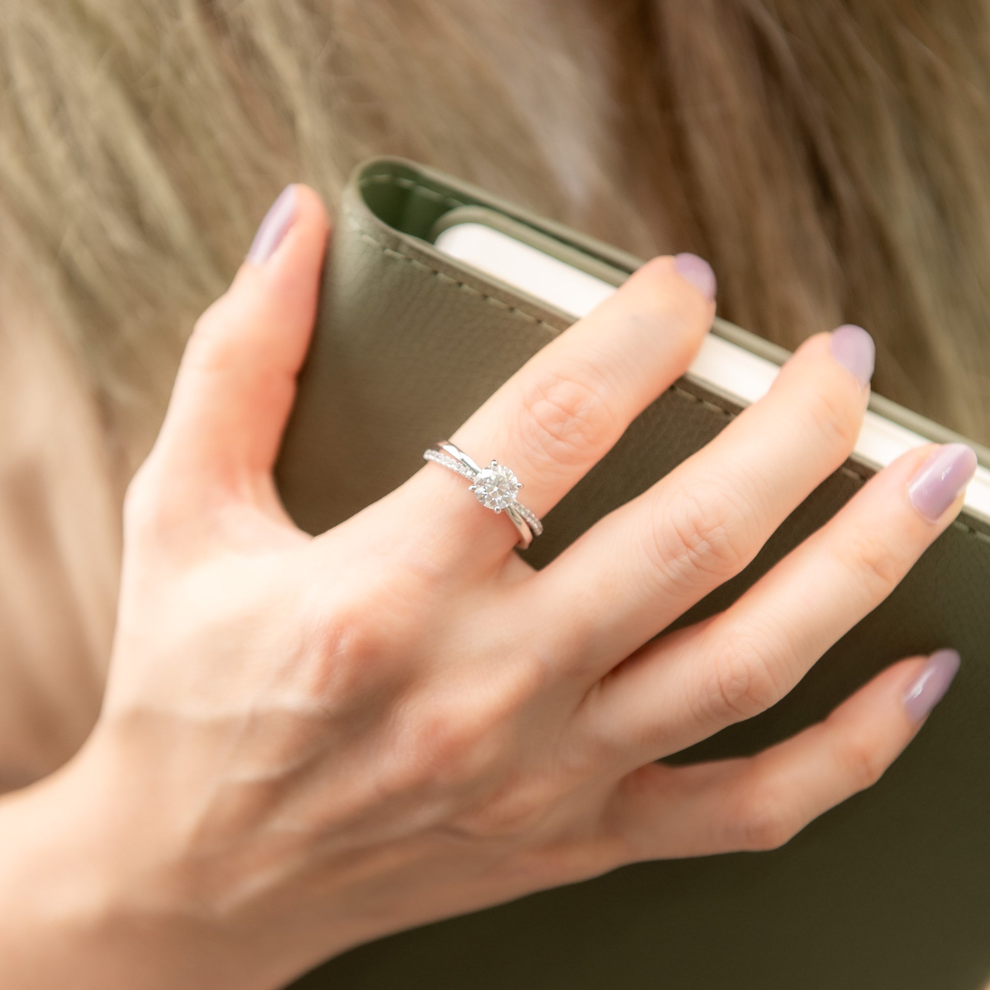 Hand holding a phone with a ring on a blurred background