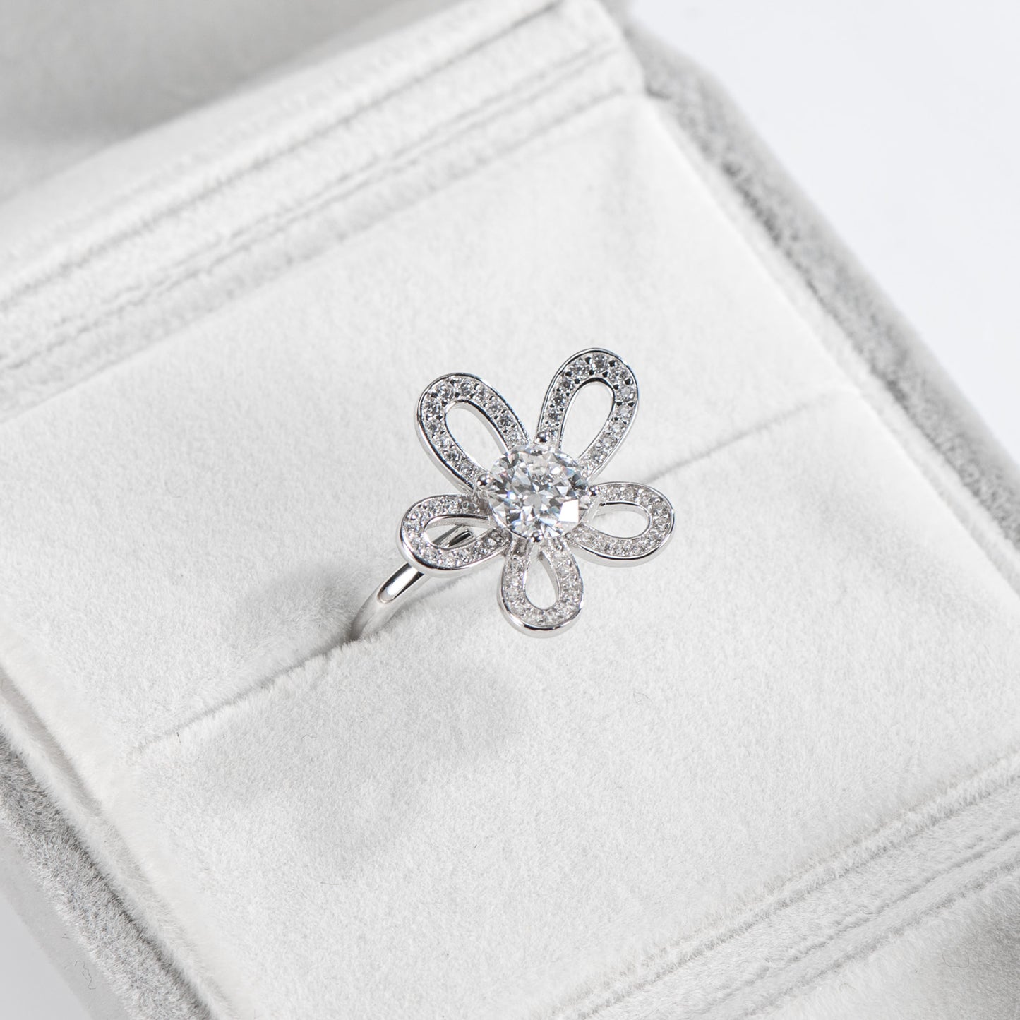 Silver butterfly-shaped ring with diamonds on a white jewelry box