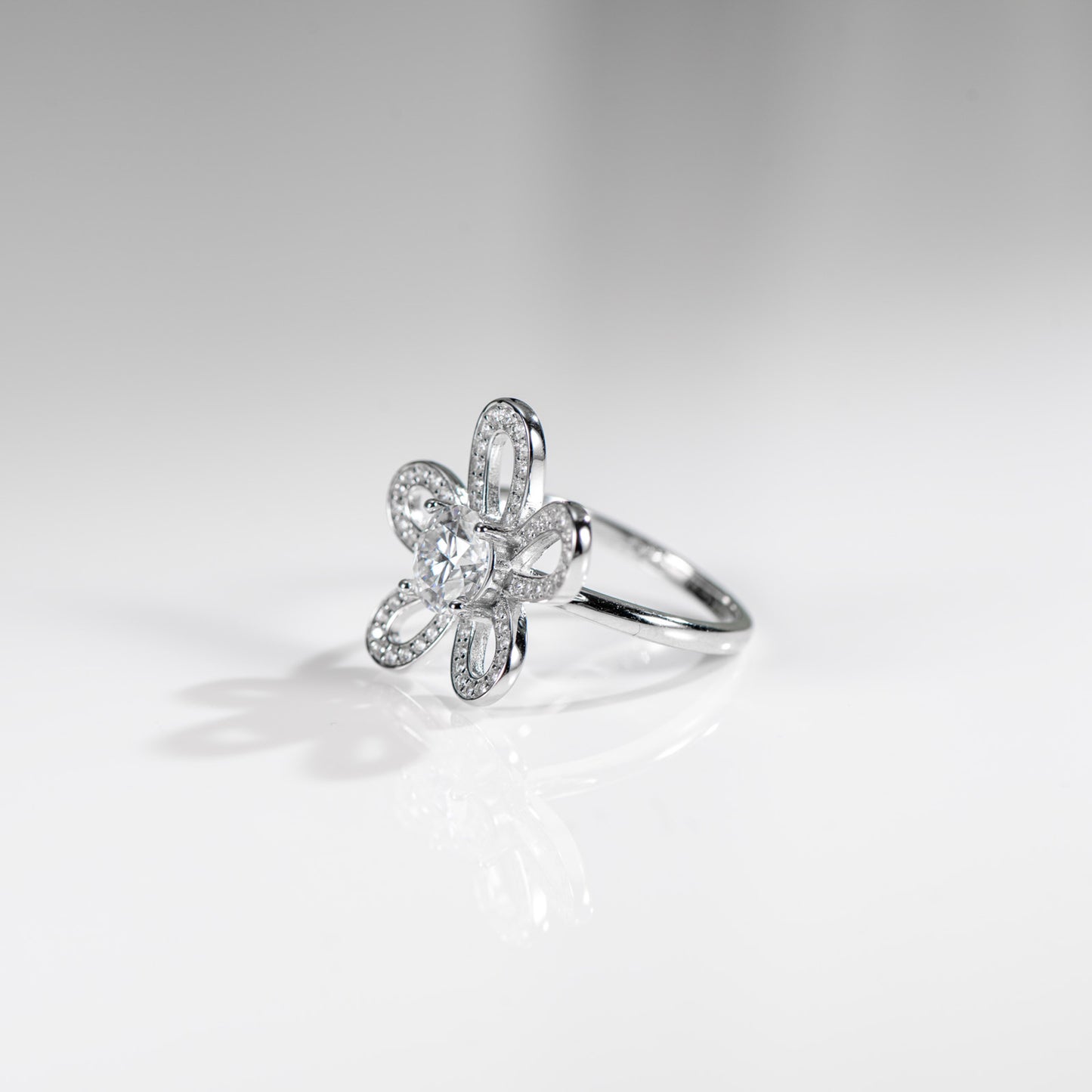 Silver ring with floral design on a light gray background
