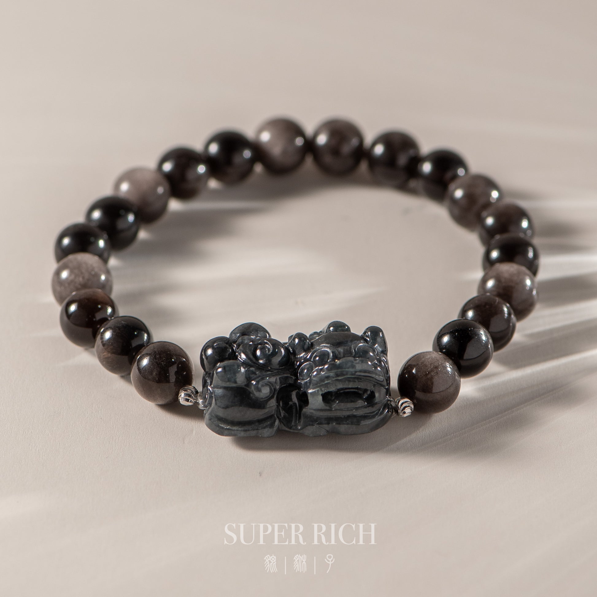Black beaded bracelet with a decorative clasp on a beige background, featuring the brand 'Super Rich'.
