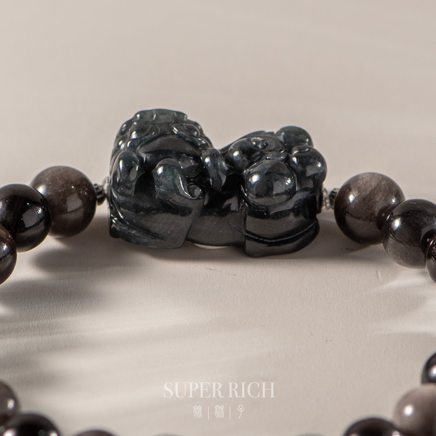 Black beaded bracelet with a large black stone clasp on a light background