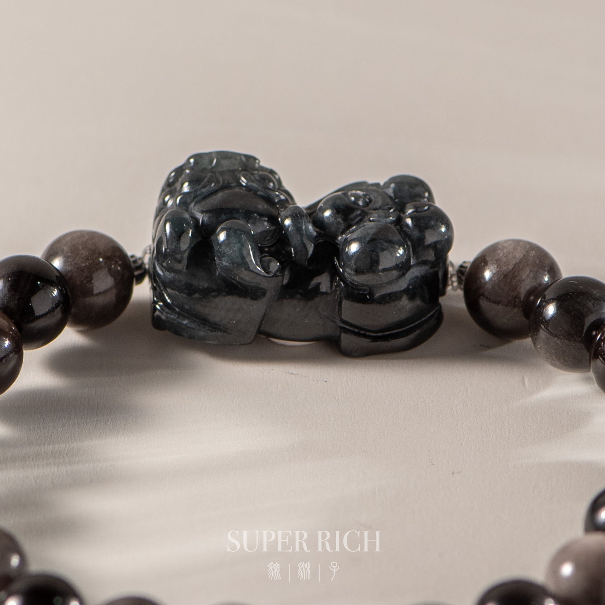 Black beaded bracelet with a large black stone clasp on a light background