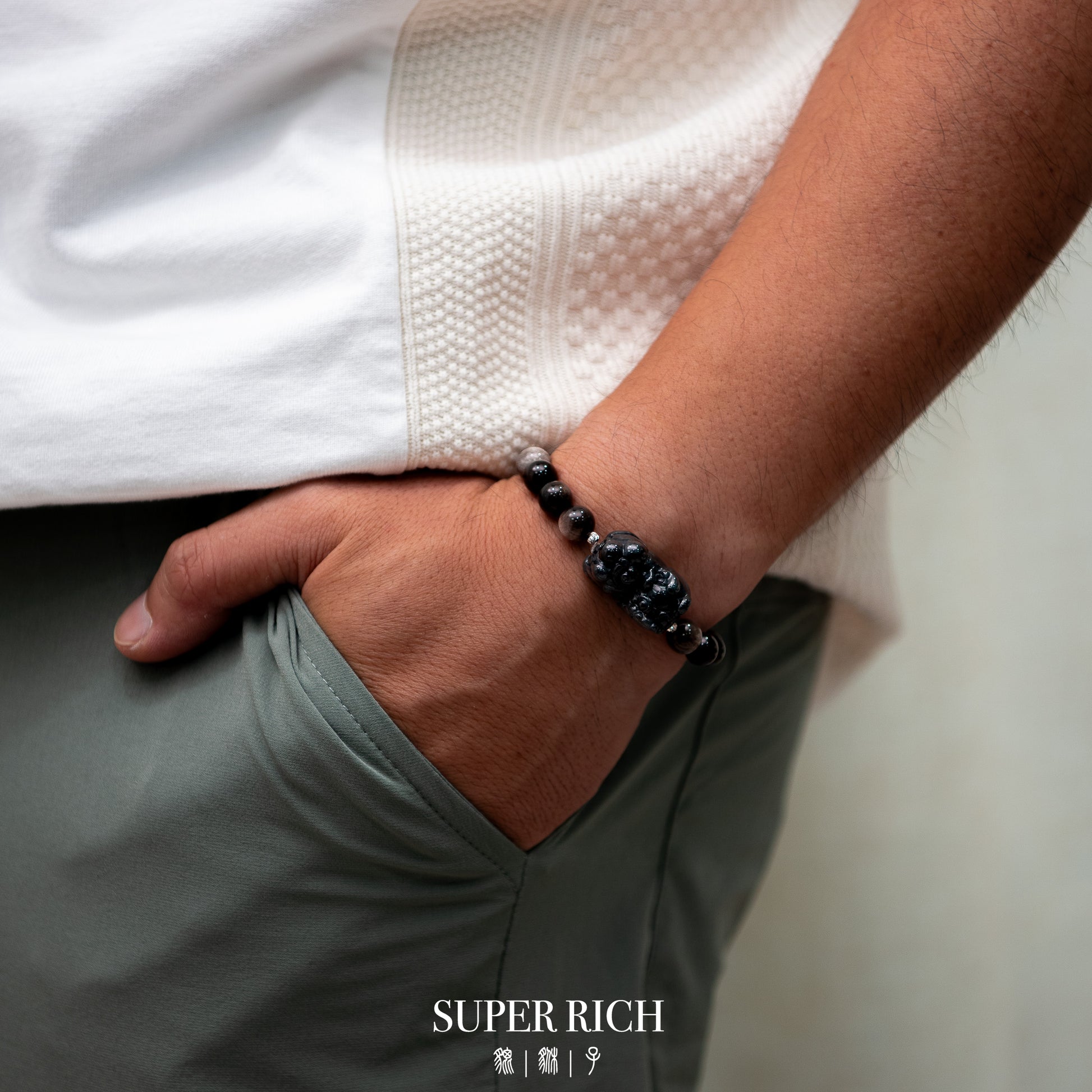 Person wearing a black beaded bracelet with a blurred background