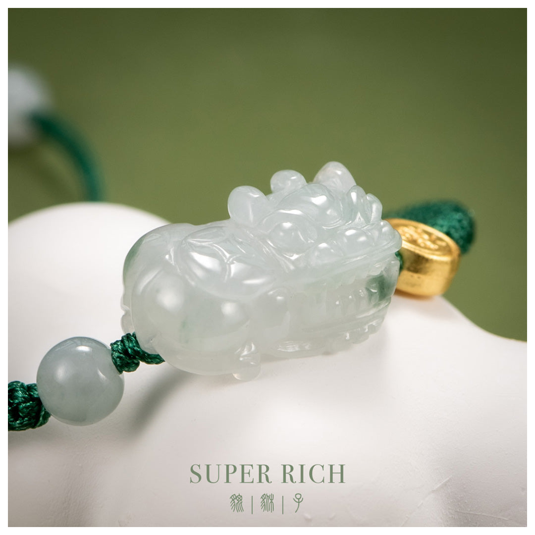 Carved jade pendant with gold accent on a white surface, labeled 'SUPER RICH'.