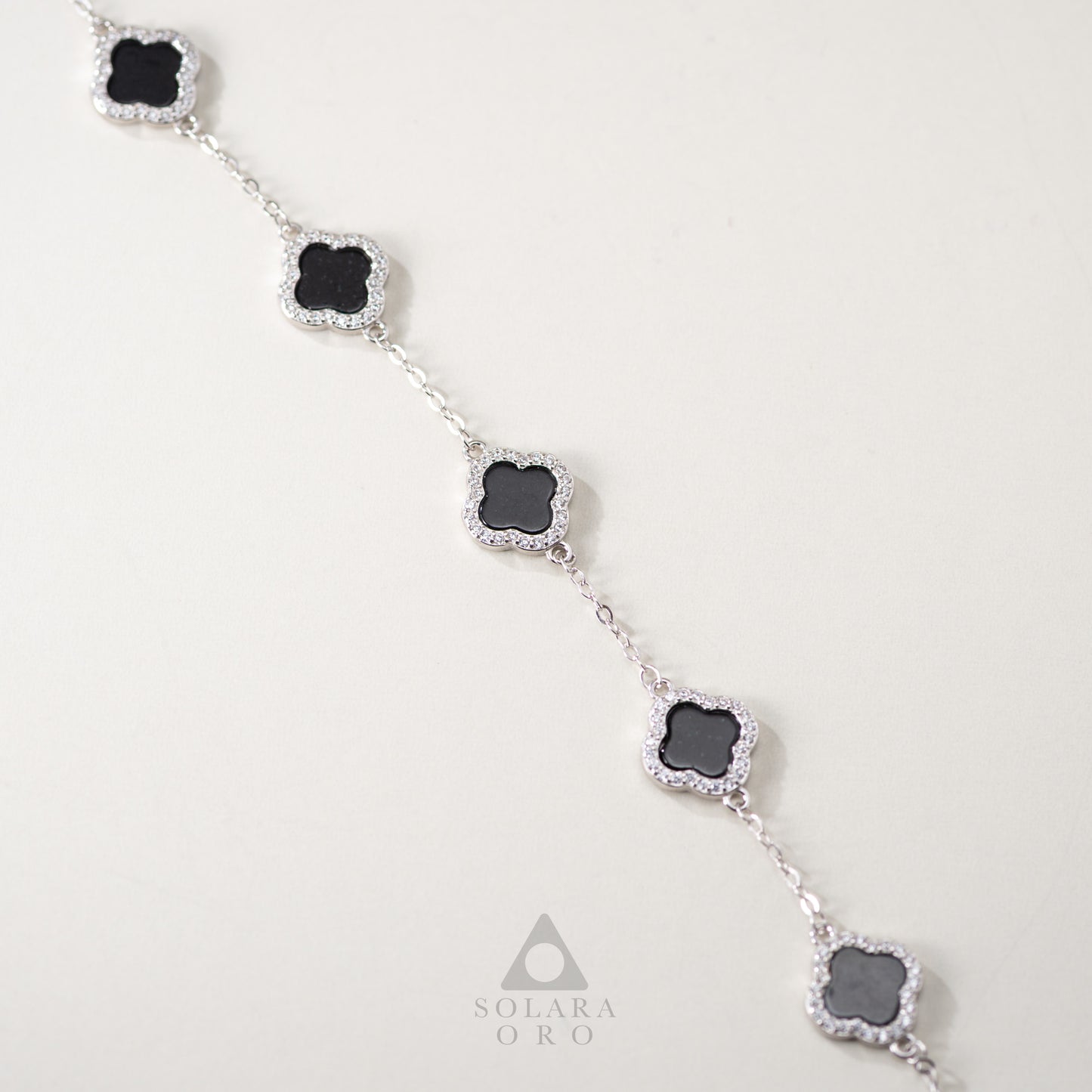 Necklace with black stones and silver accents on a light gray background, featuring the brand 'Solara Oro'.