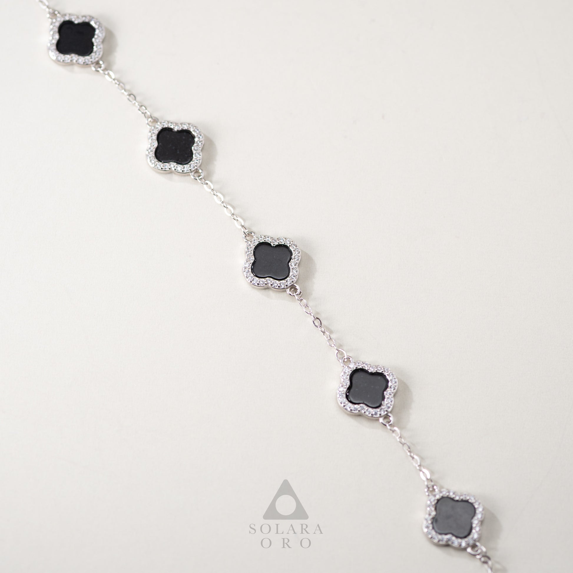 Necklace with black stones and silver accents on a light gray background, featuring the brand 'Solara Oro'.