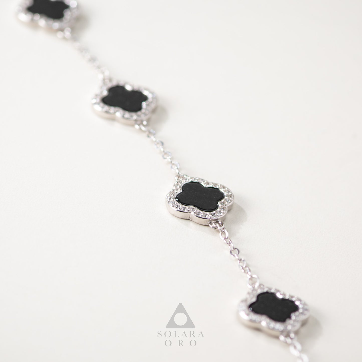 Silver bracelet with black gemstones on a white background, featuring the Solara Oro brand.