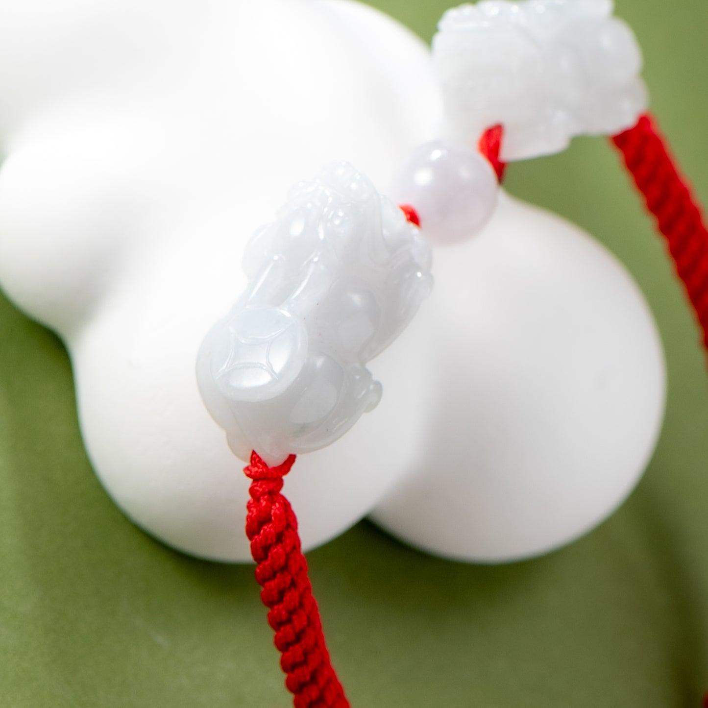 Close-up of a white dog toy with red string on a green background