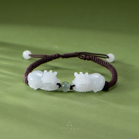 Bracelet with white animal-shaped beads on a green fabric background