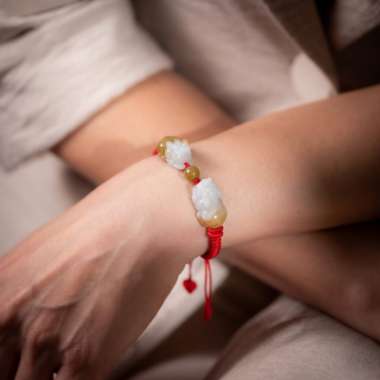 Close-up of a wrist wearing a bracelet with beads and a red string, brand 'SOLARA ORO' visible.