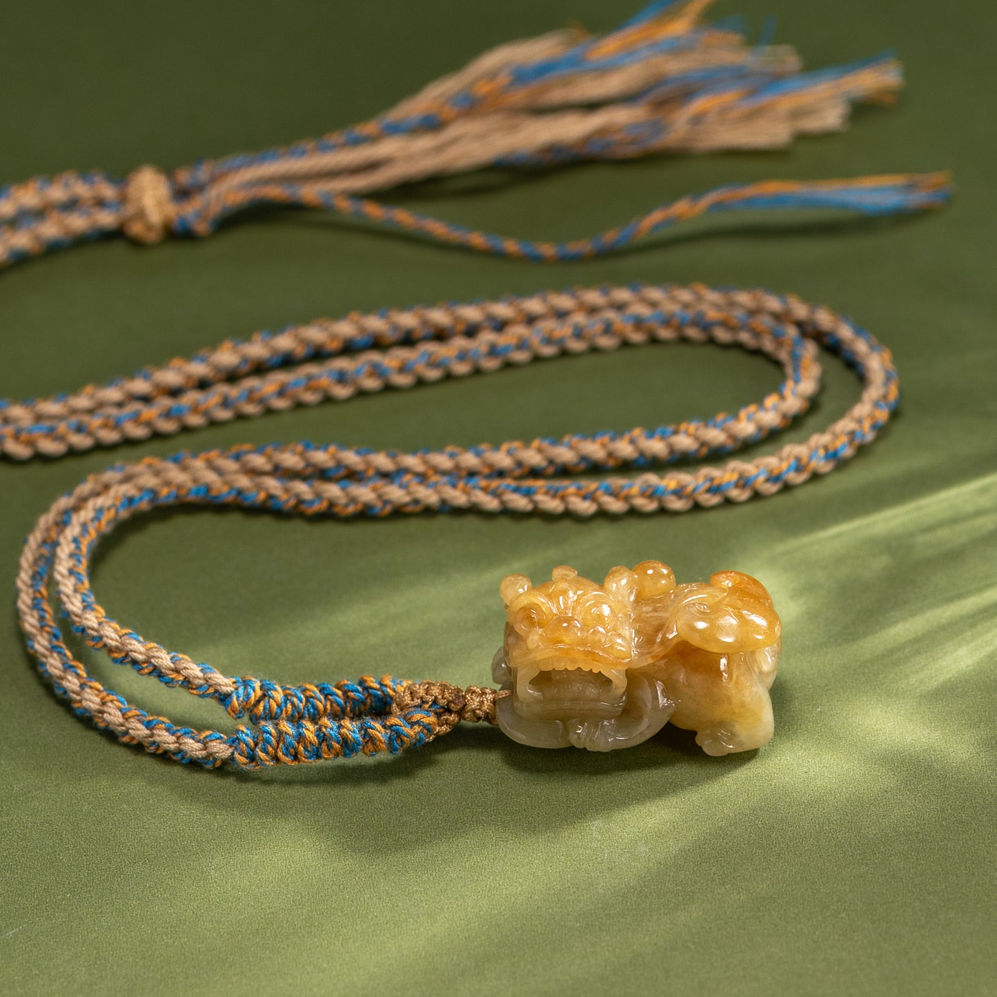 Bracelet with a stone pendant on a green fabric background