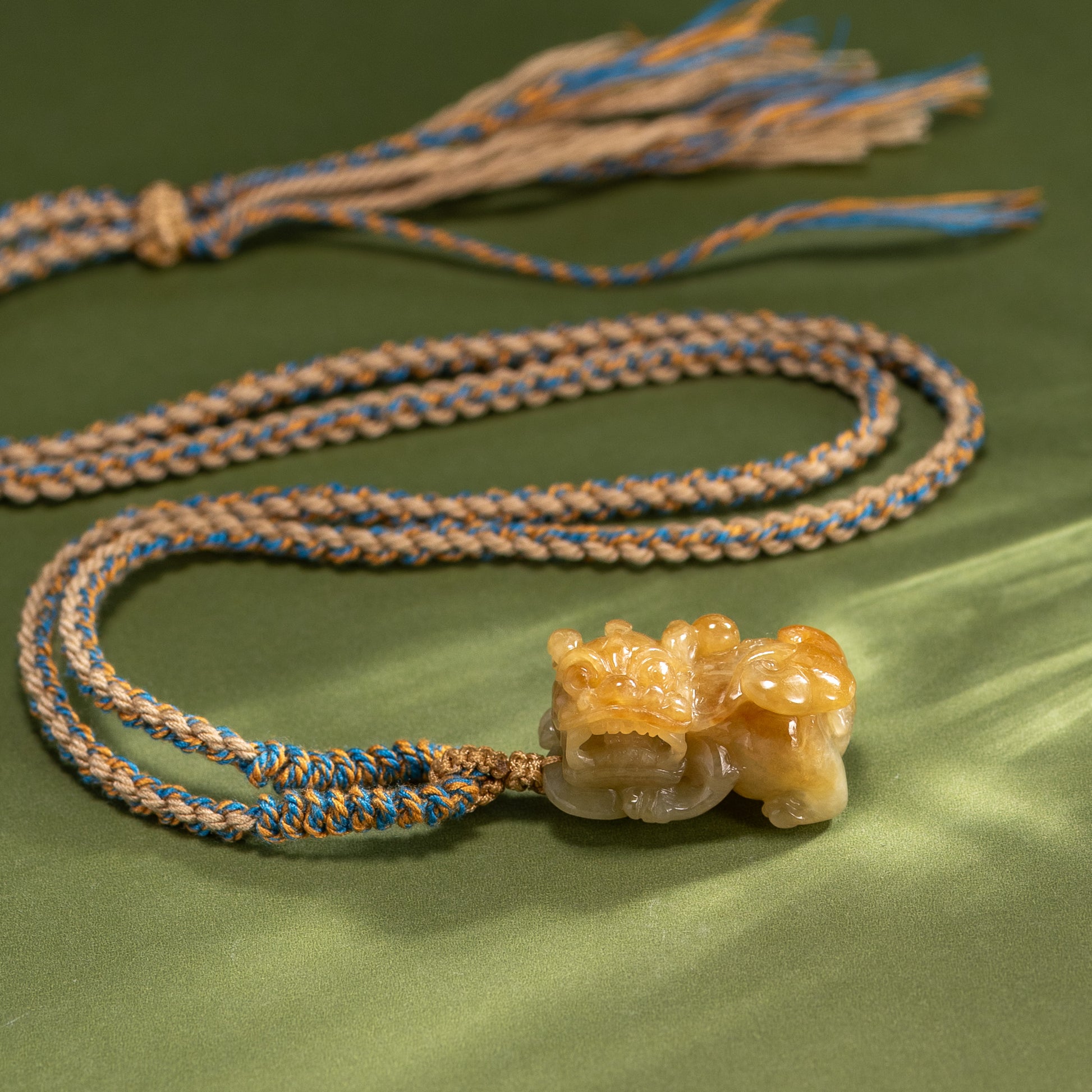 Bracelet with a stone pendant on a green fabric background