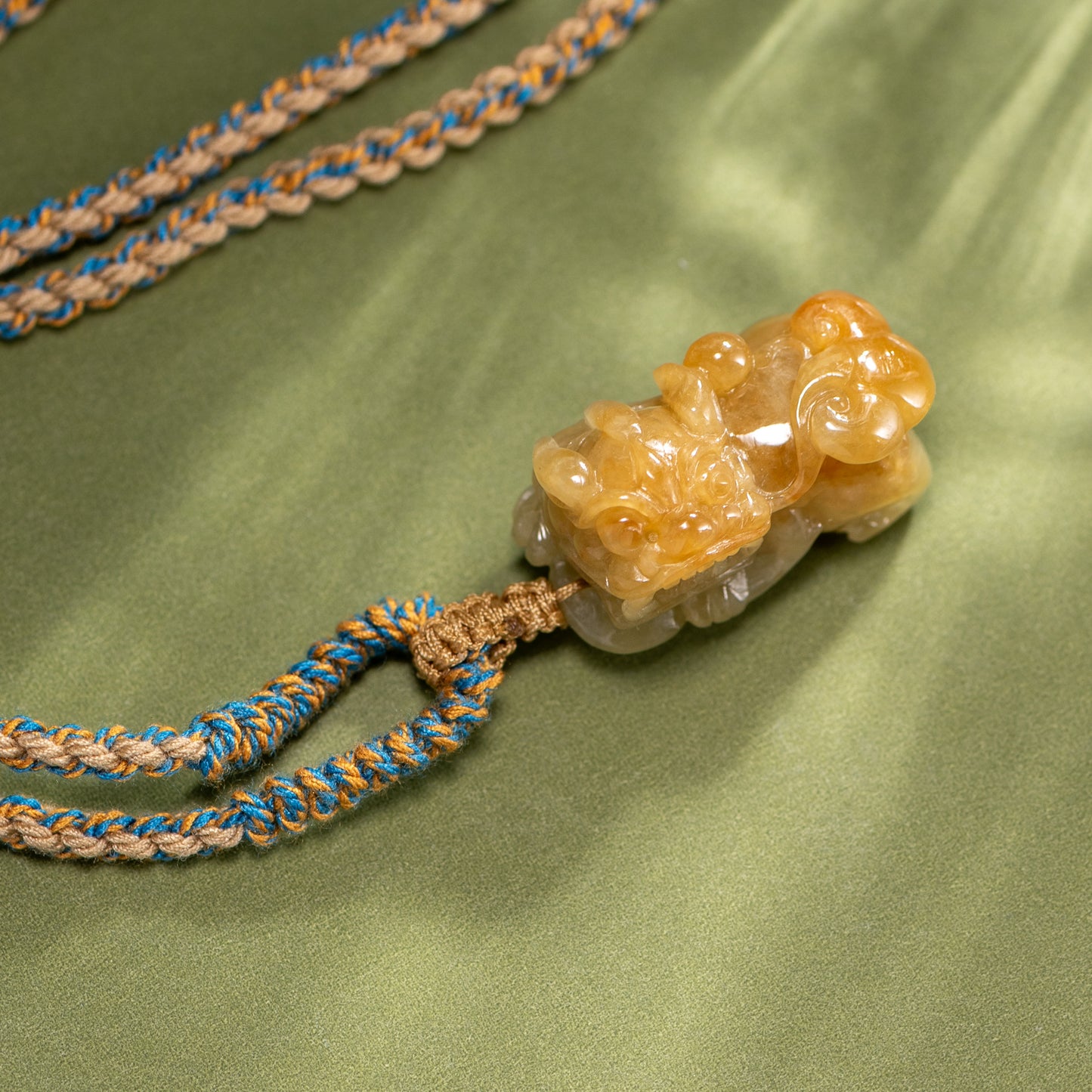 Decorative necklace with a stone pendant on a green fabric background
