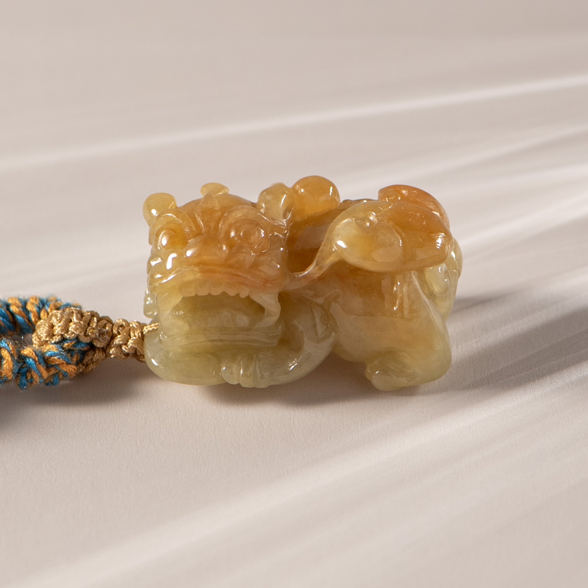 Carved stone tiger pendant on a white background