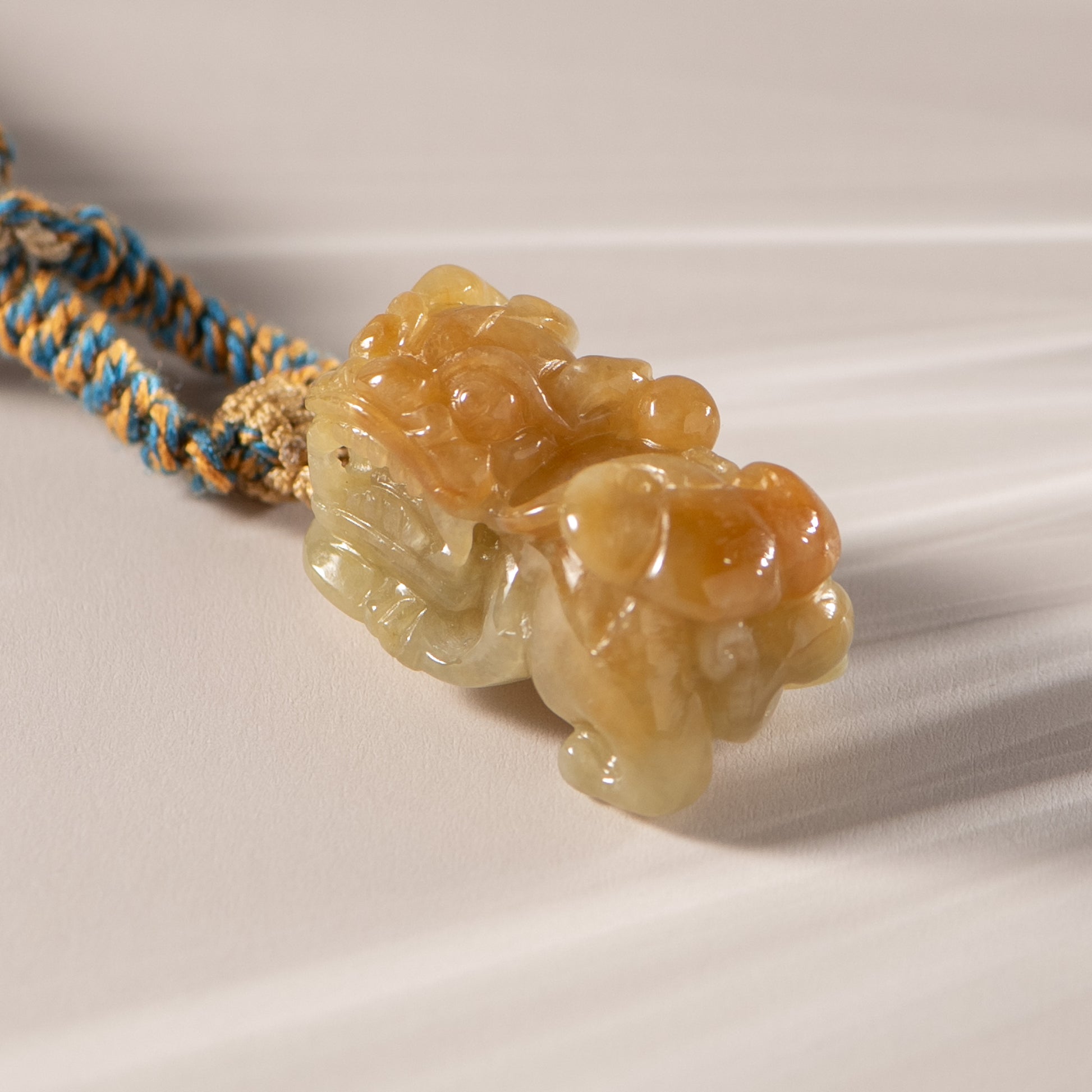 Carved stone pendant with a rope on a light background
