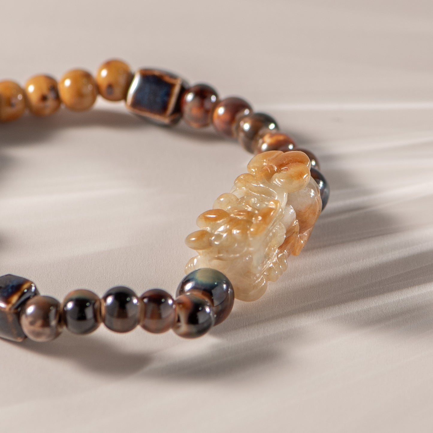 Beaded bracelet with brown and beige beads on a neutral background