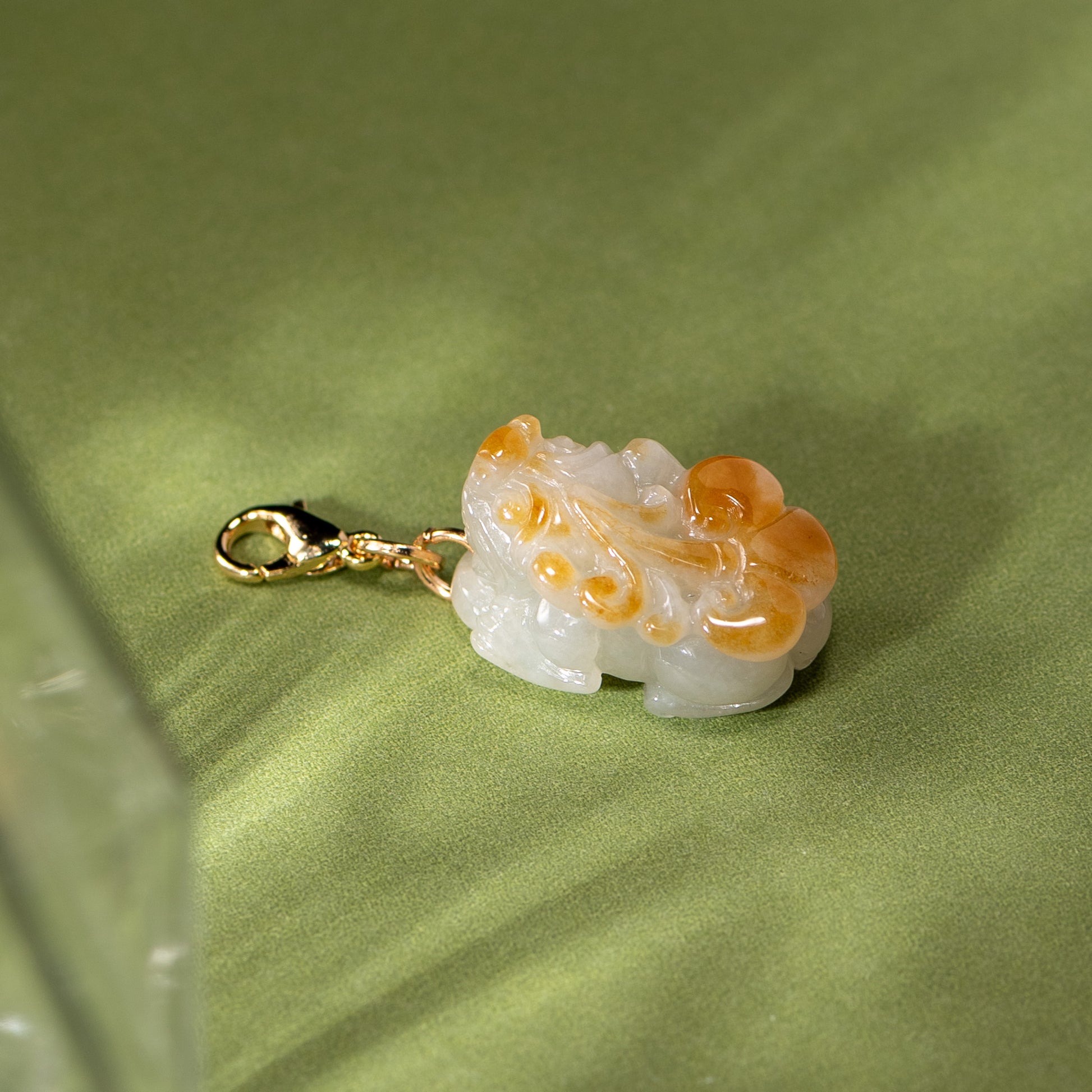 Decorative pendant with gold chain on a green fabric background