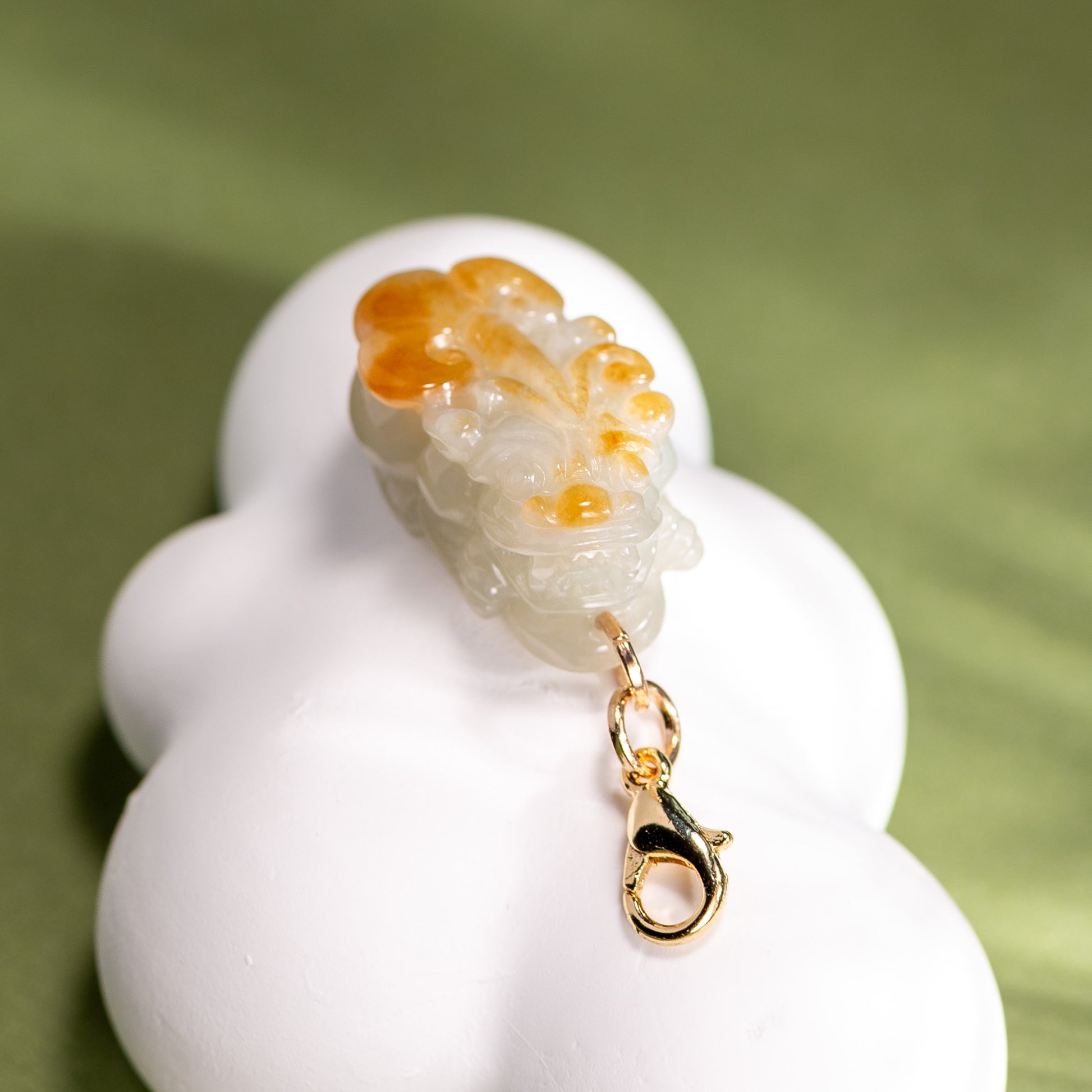 Decorative charm with a lobster design on a white base against a green background