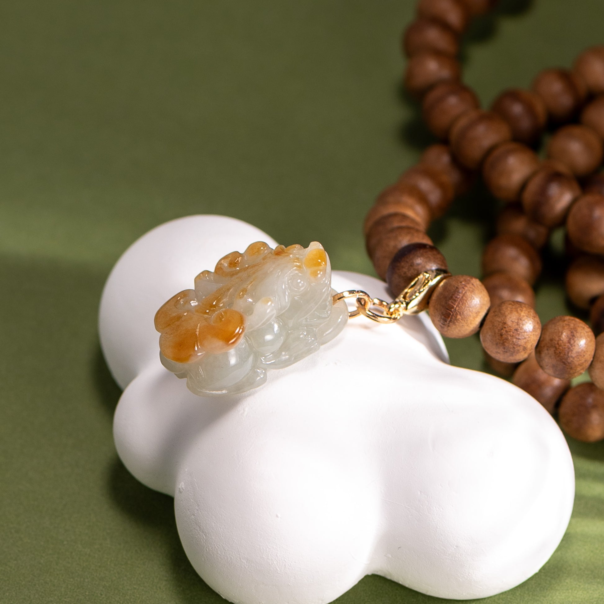 Decorative item with a white base and gold accent on a green background