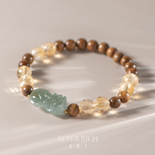 Bracelet with wooden beads and a green stone on a reflective surface, featuring the brand 'Super Rich'.